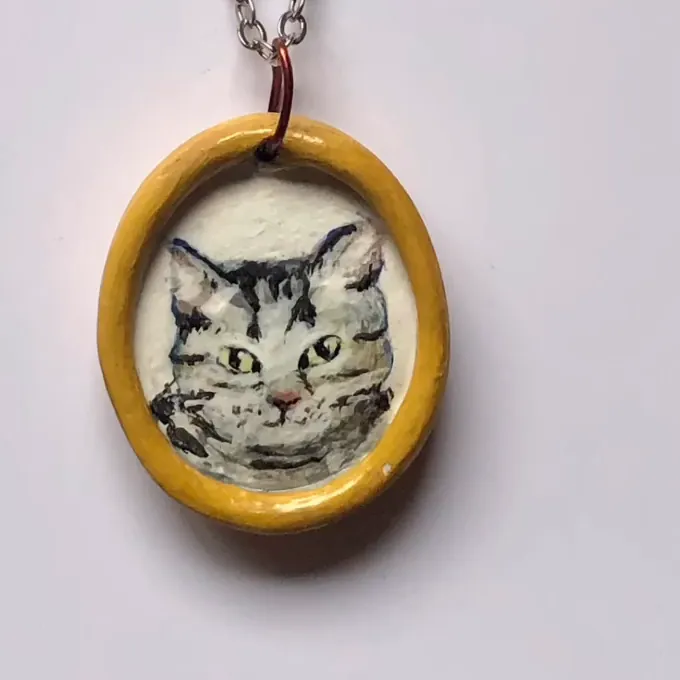 Charm ovalado con el retrato pintado de un gato atigrado