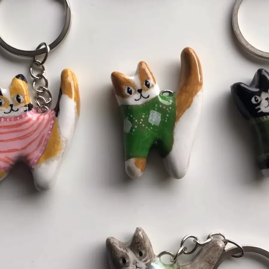 Llaveros de gatitos con sweater sobre una mesa