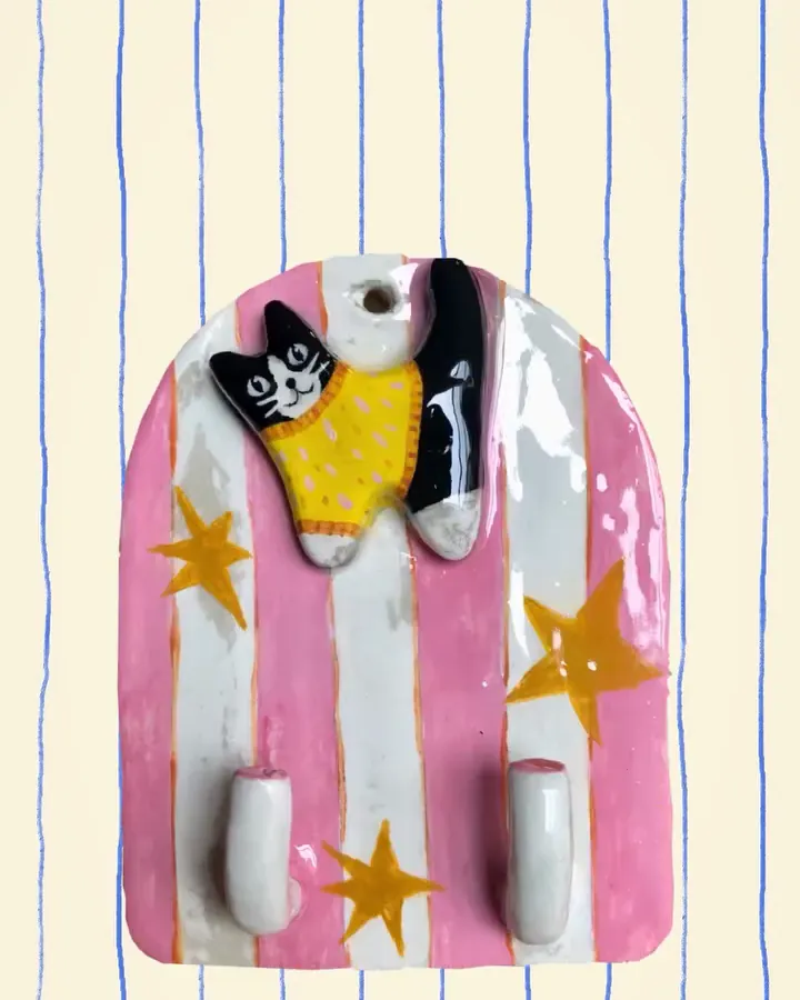 Colgador de llaves con rayas rosadas, estrellas y un gatito con sweater amarillo